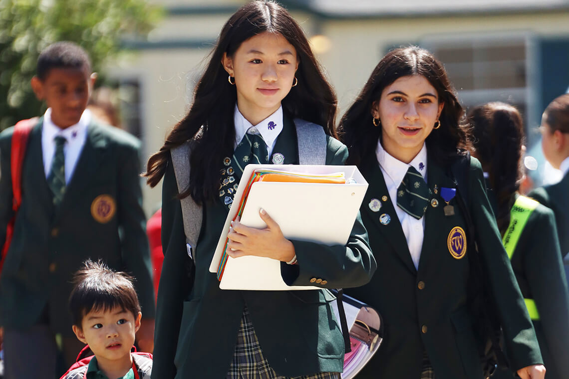 Students in school uniforms walking together on campus.