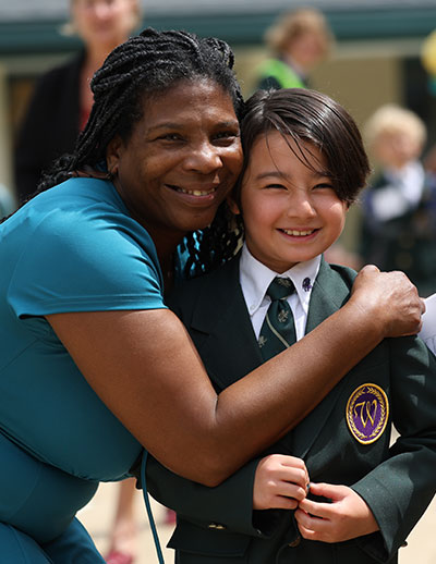 Teacher hugging smiling student