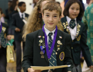 boy in school uniform with academics awards
