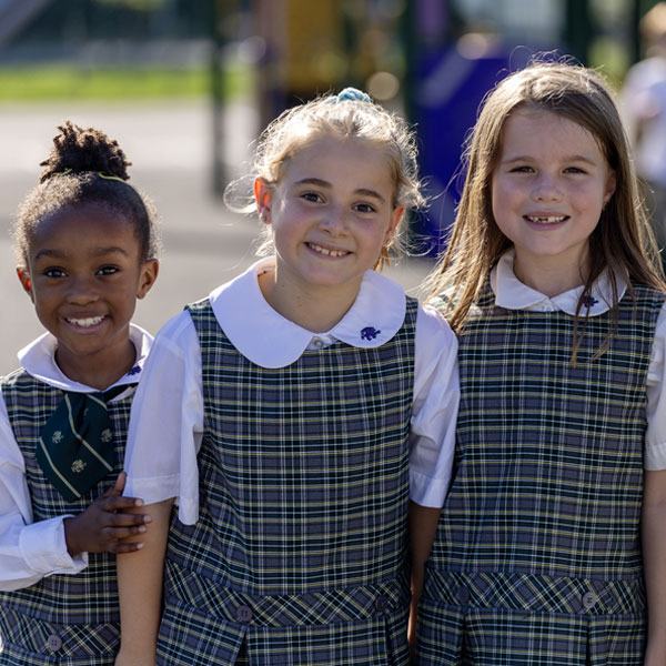 girls-on-playground 3 girls smiling on playground in school uniform