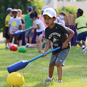 Boy hitting a ball on grass field