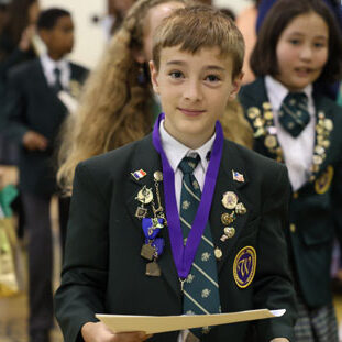 academics-mega boy in school uniform with academics awards
